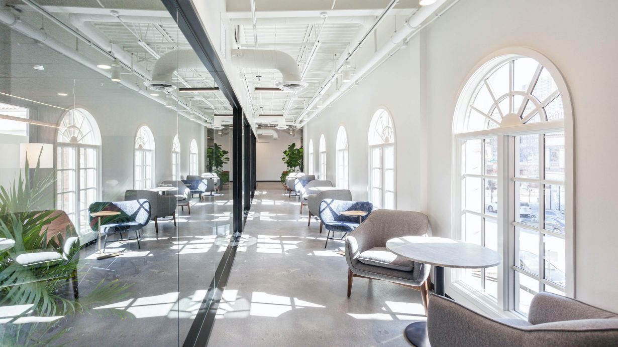 Casual seating areas are arranged along the hallway, making the most of the building’s French windows.